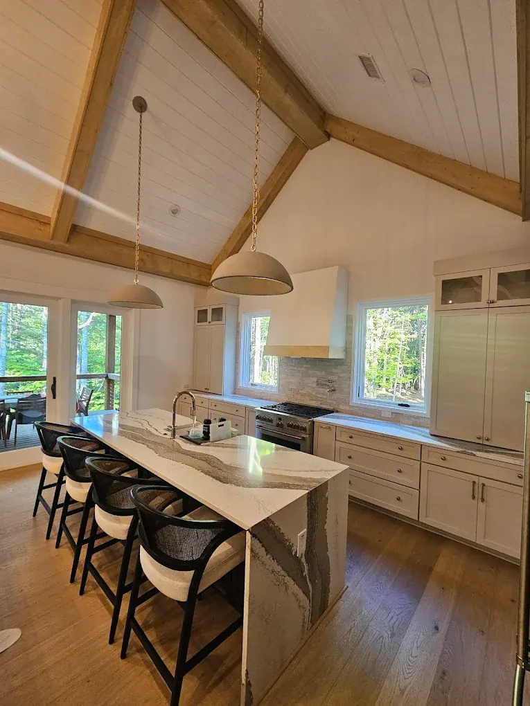 Bright, freshly cleaned kitchen with marble island and wood floors